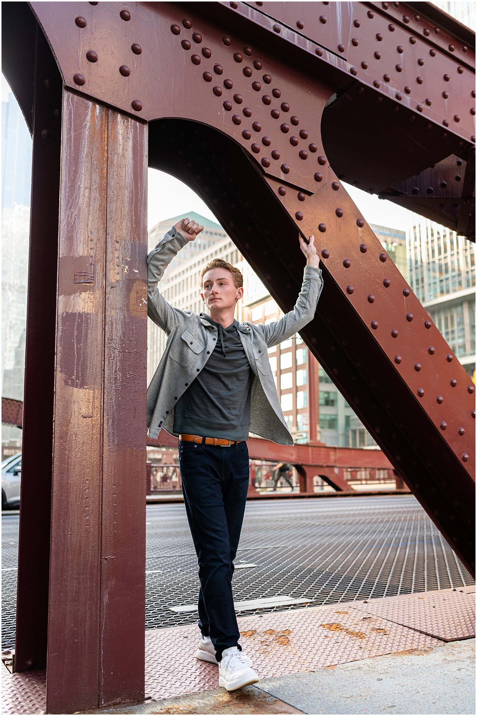 What a Senior Session at SJP Looks Like – high school senior boy wearing black jeans, gray button up, and white sneakers on Chicago bridge – Sarah Jane Photography is a high school senior photographer serving Bourbonnais & Chicagoland.