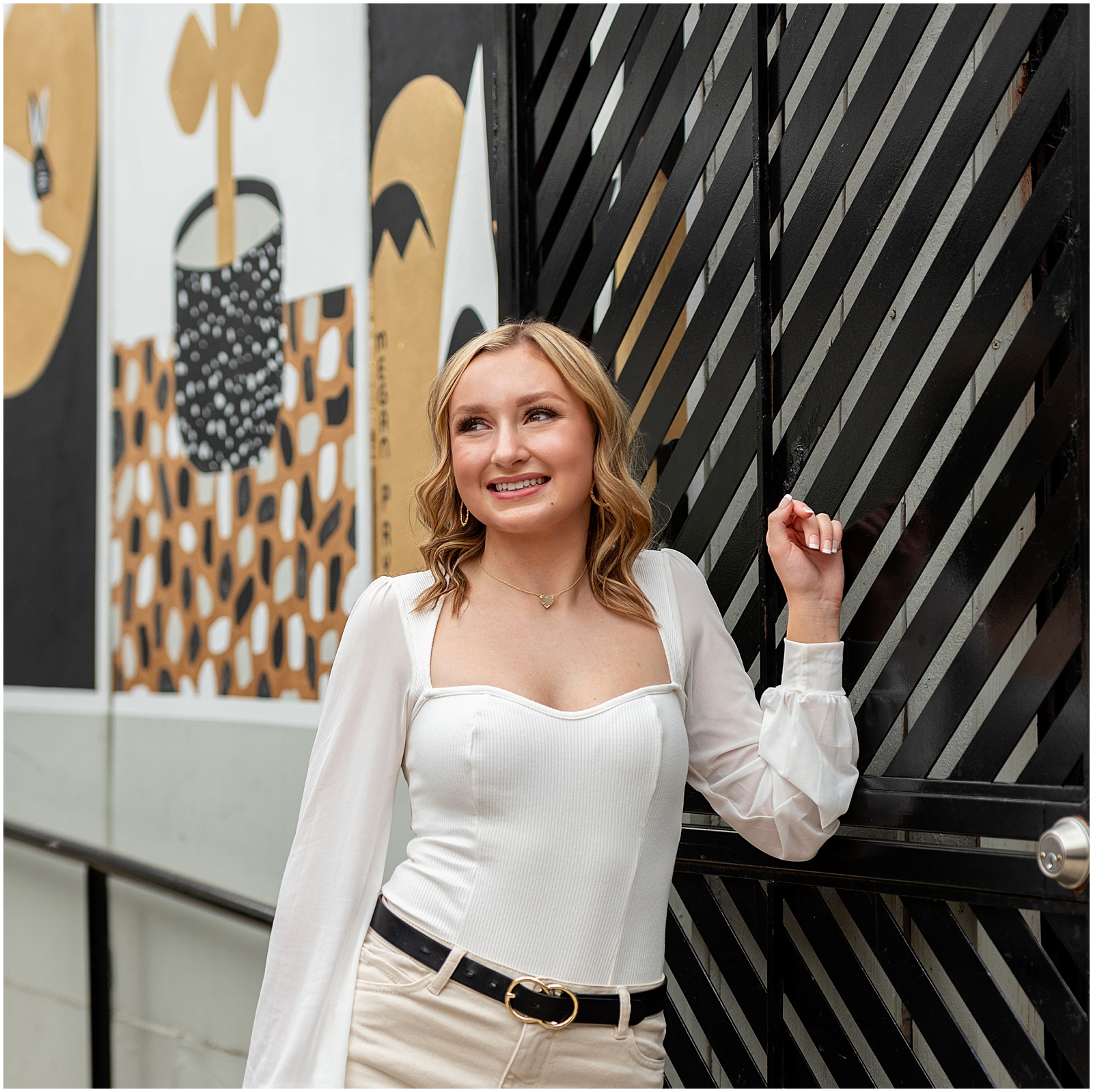 What a Senior Session at SJP Looks Like – high school senior girl wearing cream pants and white shirt standing in front of a mural – Sarah Jane Photography is a high school senior photographer serving Bourbonnais & Chicagoland.